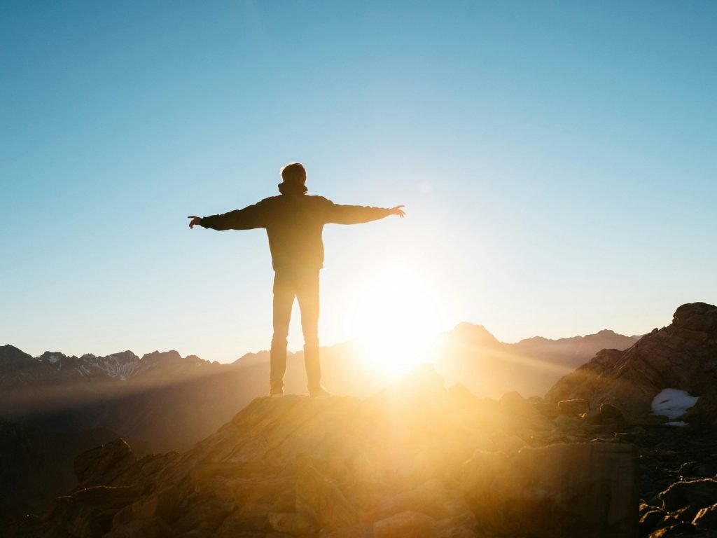 Person in front of a sunrise representing a new dawn as IoT connectivity is about to get a shake-up with the SGP.32 standard and boost new eSO (eSIM Orchestrator) platforms.